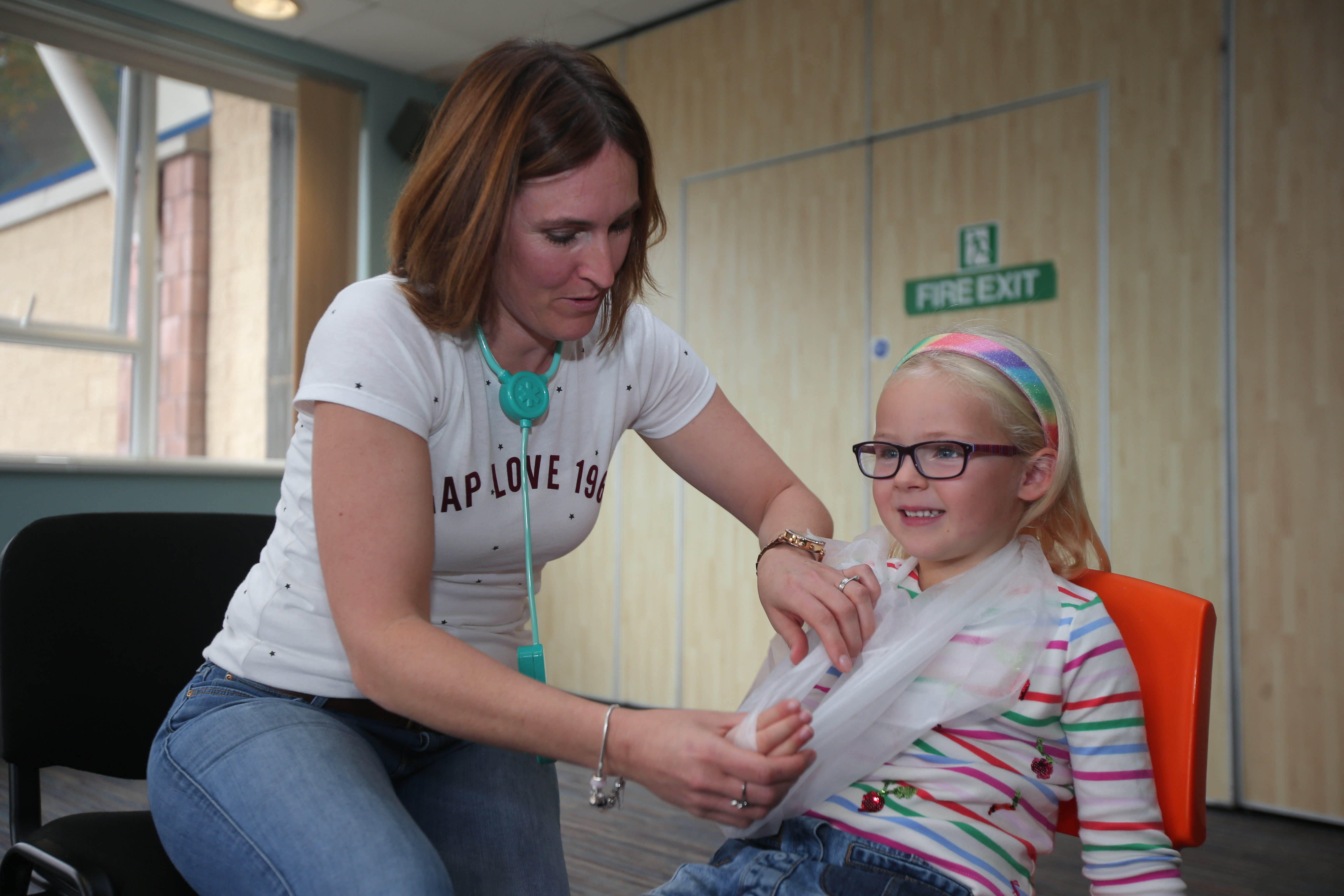 Instructor applying bandage to girl