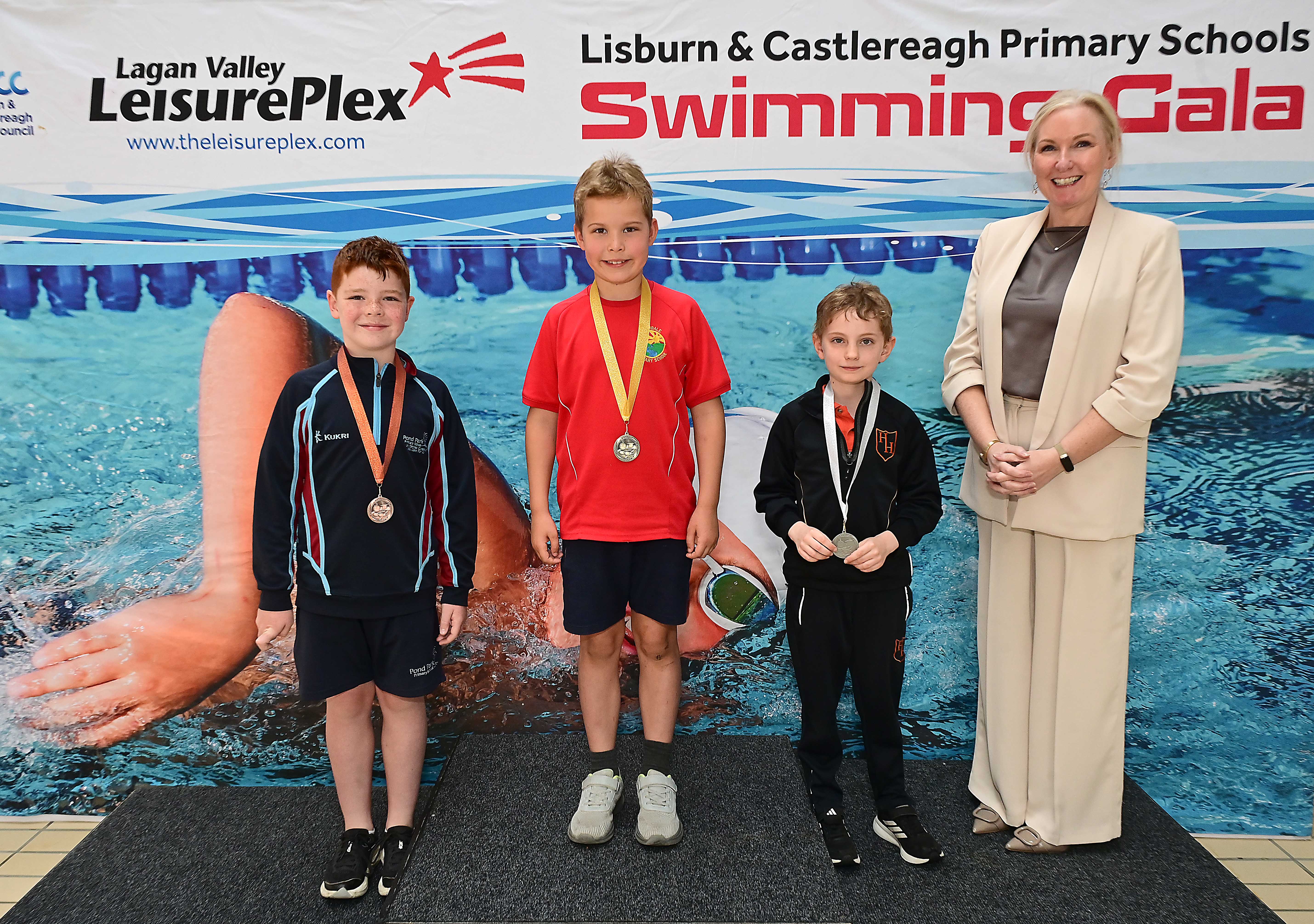Louise Moore, Director of Leisure & Community Wellbeing presents Event 1 Backstroke winners:  1st Lochlan O’ Neill, (Riverdale), 2nd Ethan Donaghy (Harmony Hill) and 3rd Harry Elliott (Pond Park)