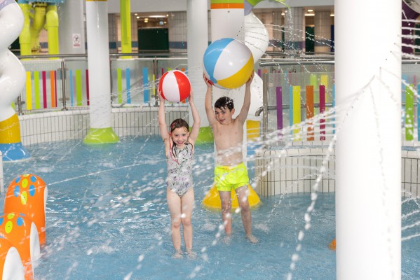 Two girls in swimming pool with water noodles