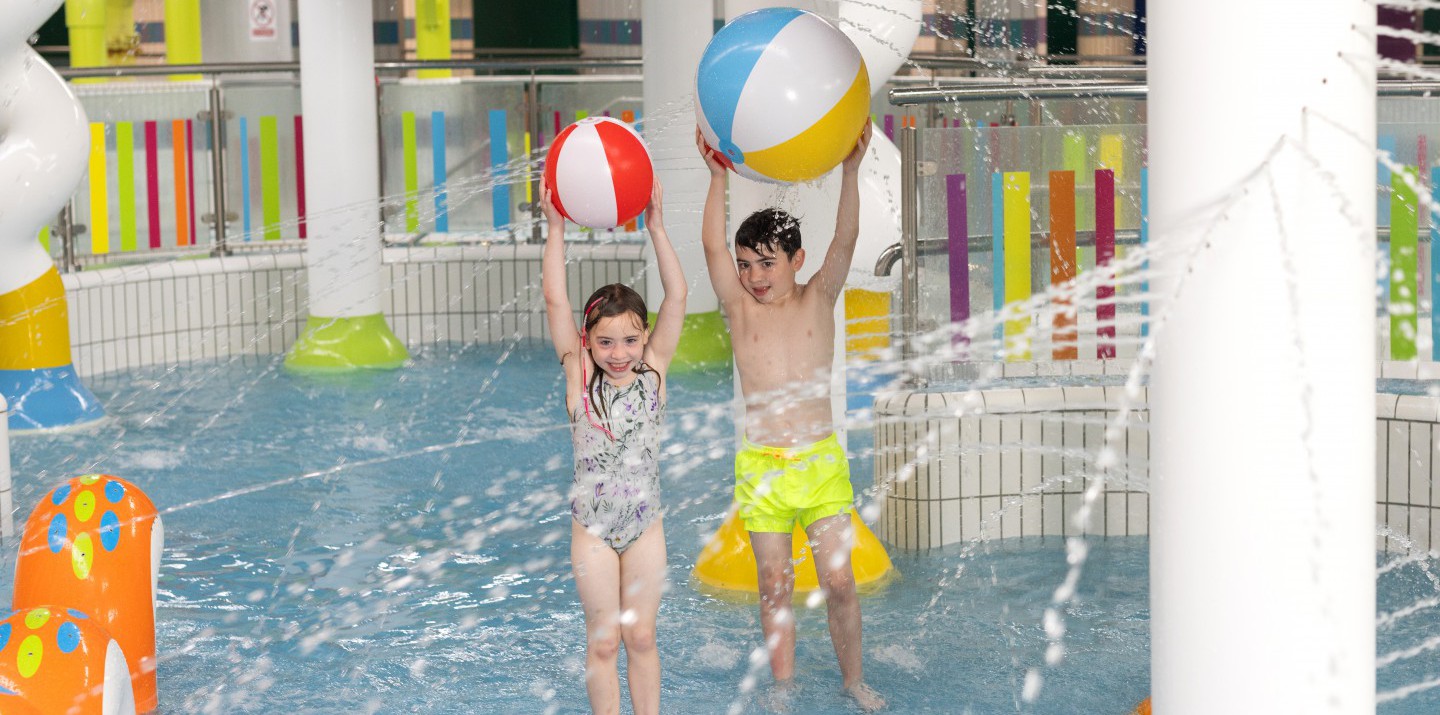 Leisure pool boy and girl splashing
