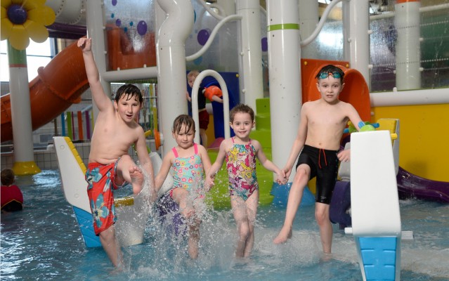 Four kids splashing in Pool